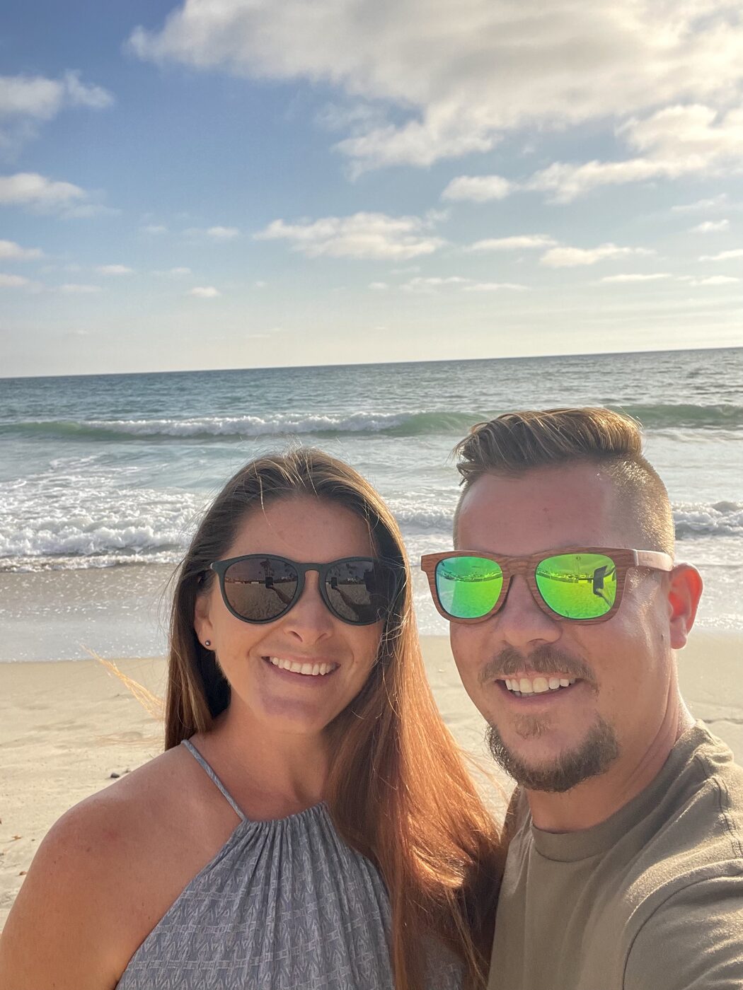 Karlee and Jesse smiling on the beach at golden hour