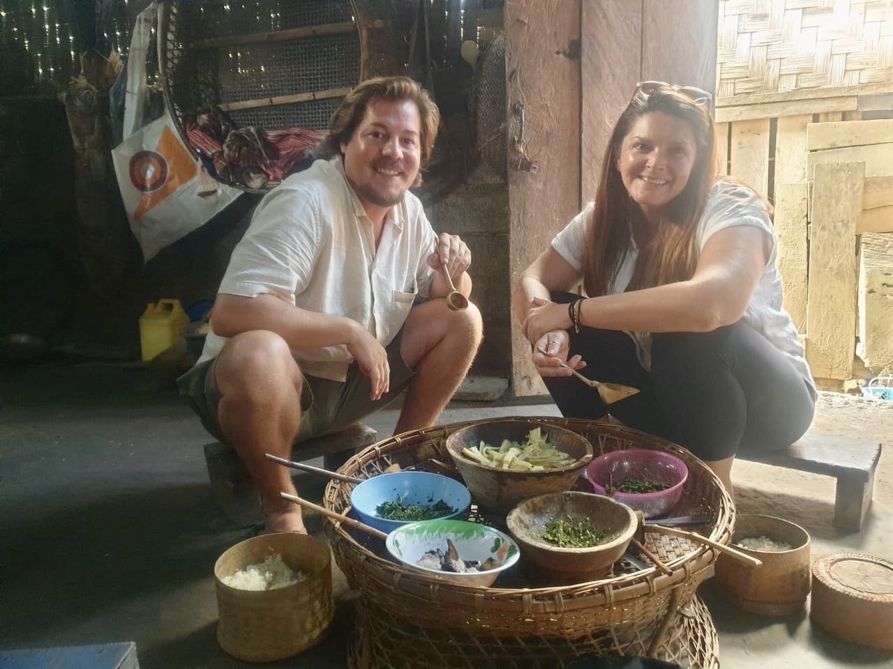 Jesse and Karlee seated on the floor around baskets of home-cooked food