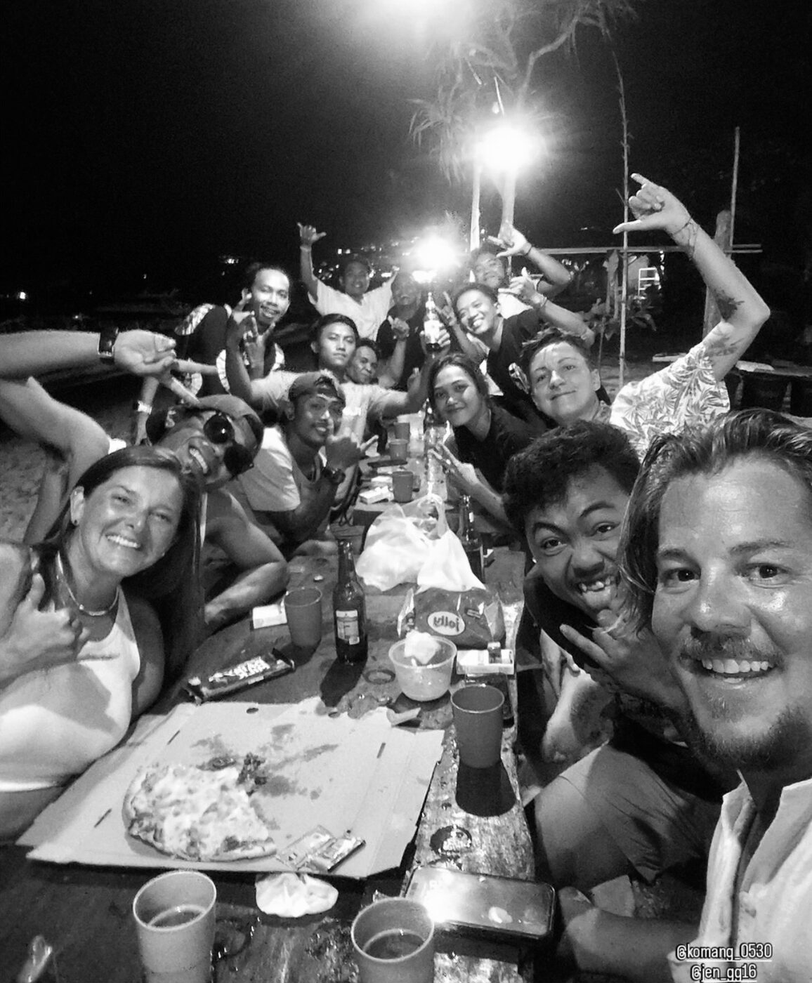 A long table of friends celebrating at night on Nusa Lembongan
