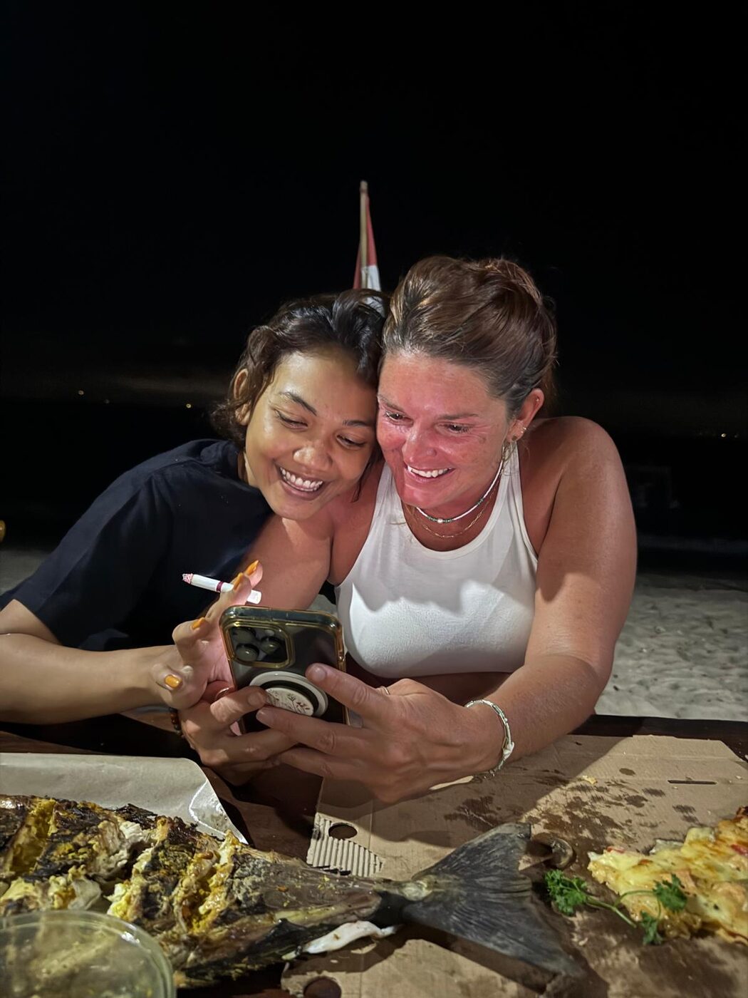 Karlee and a friend from the island laughing over a camera