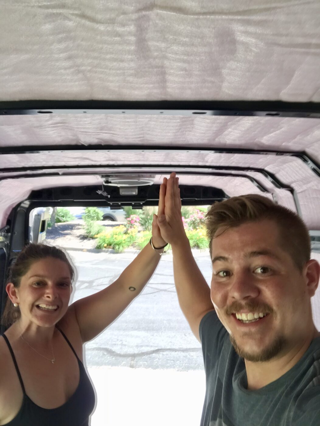 Karlee and Jesse high-fiving inside the empty van shell
