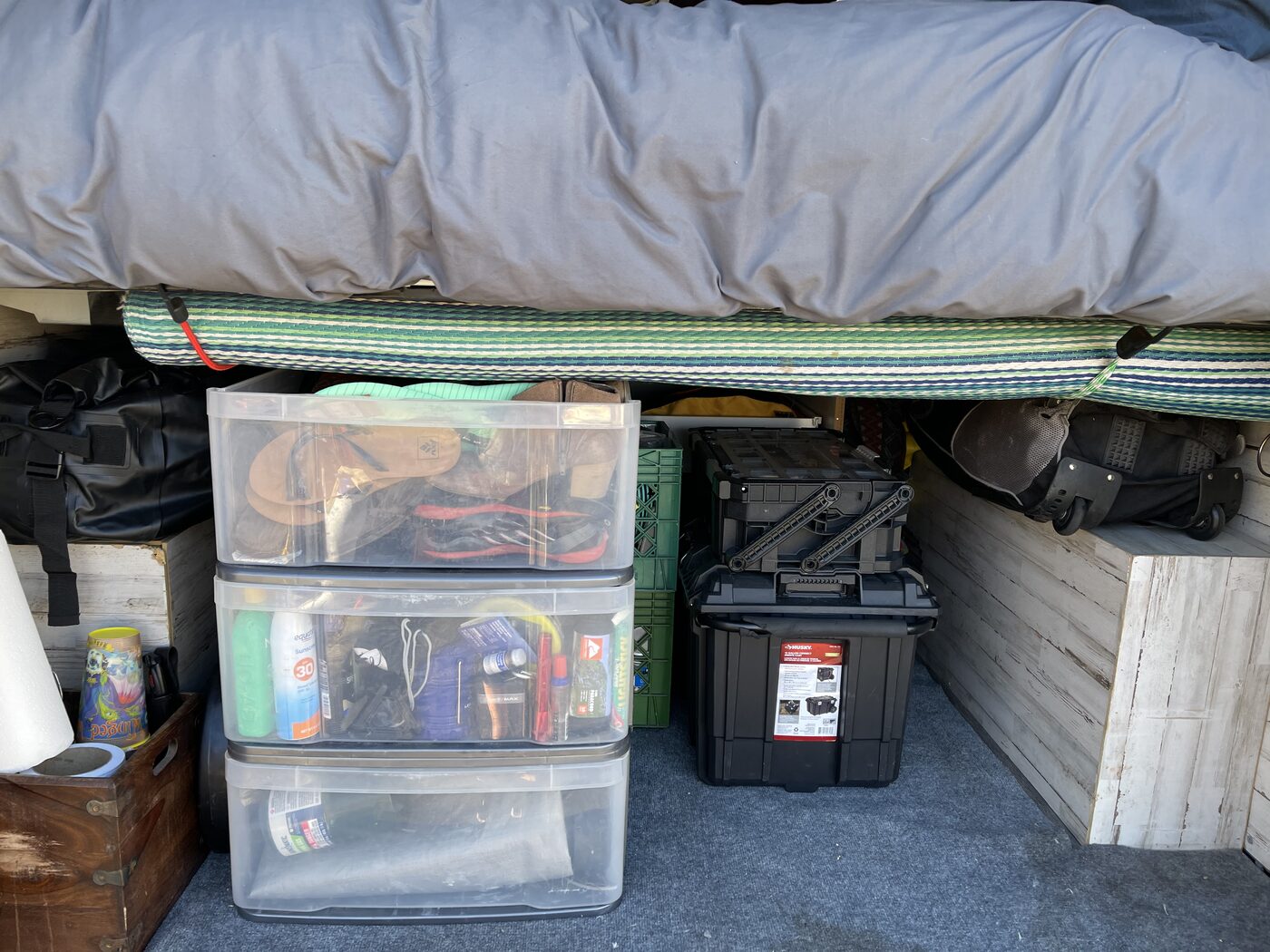Clear storage bins tucked under the bed platform