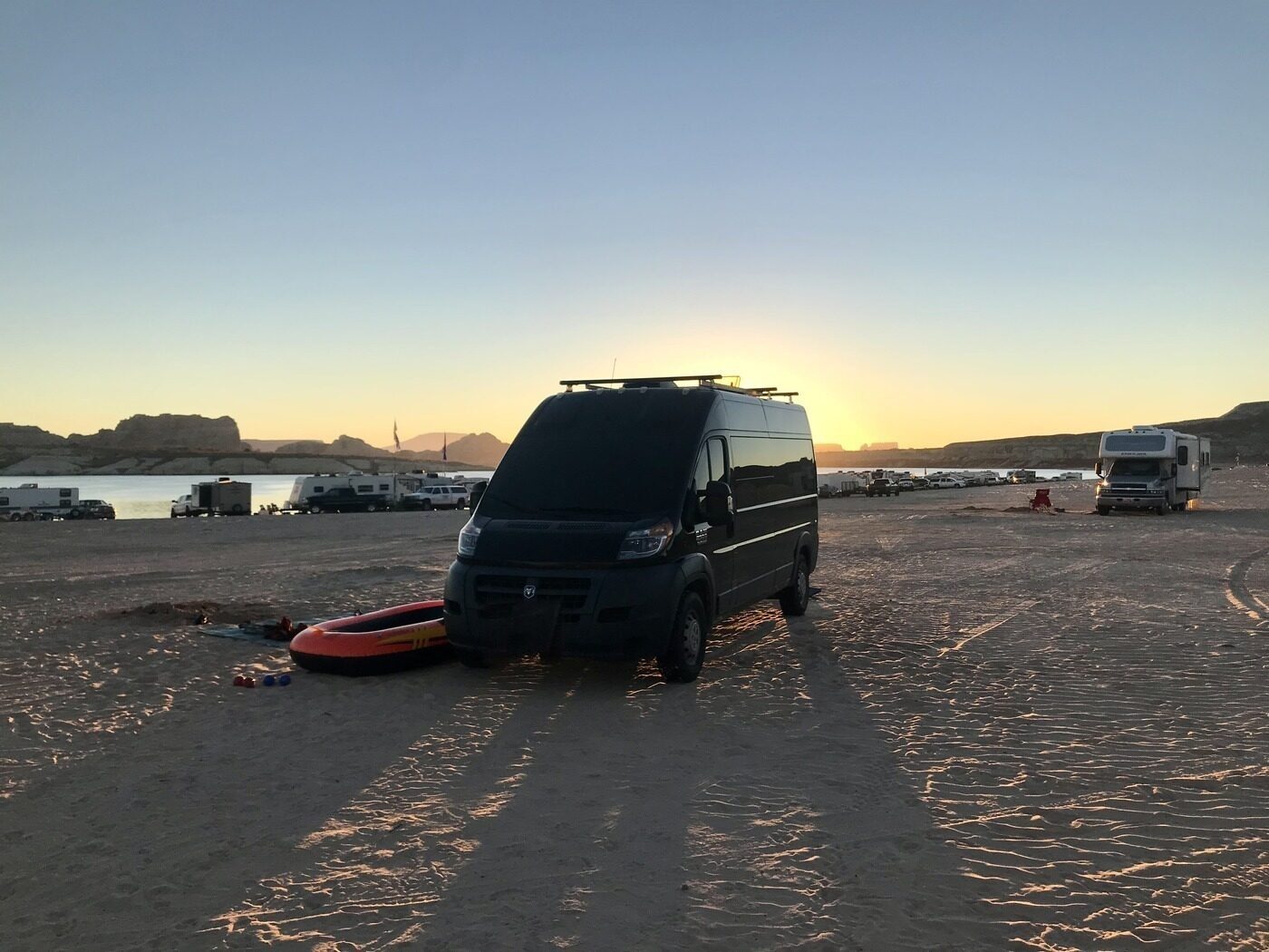The van parked at the edge of Lake Powell, red rock behind