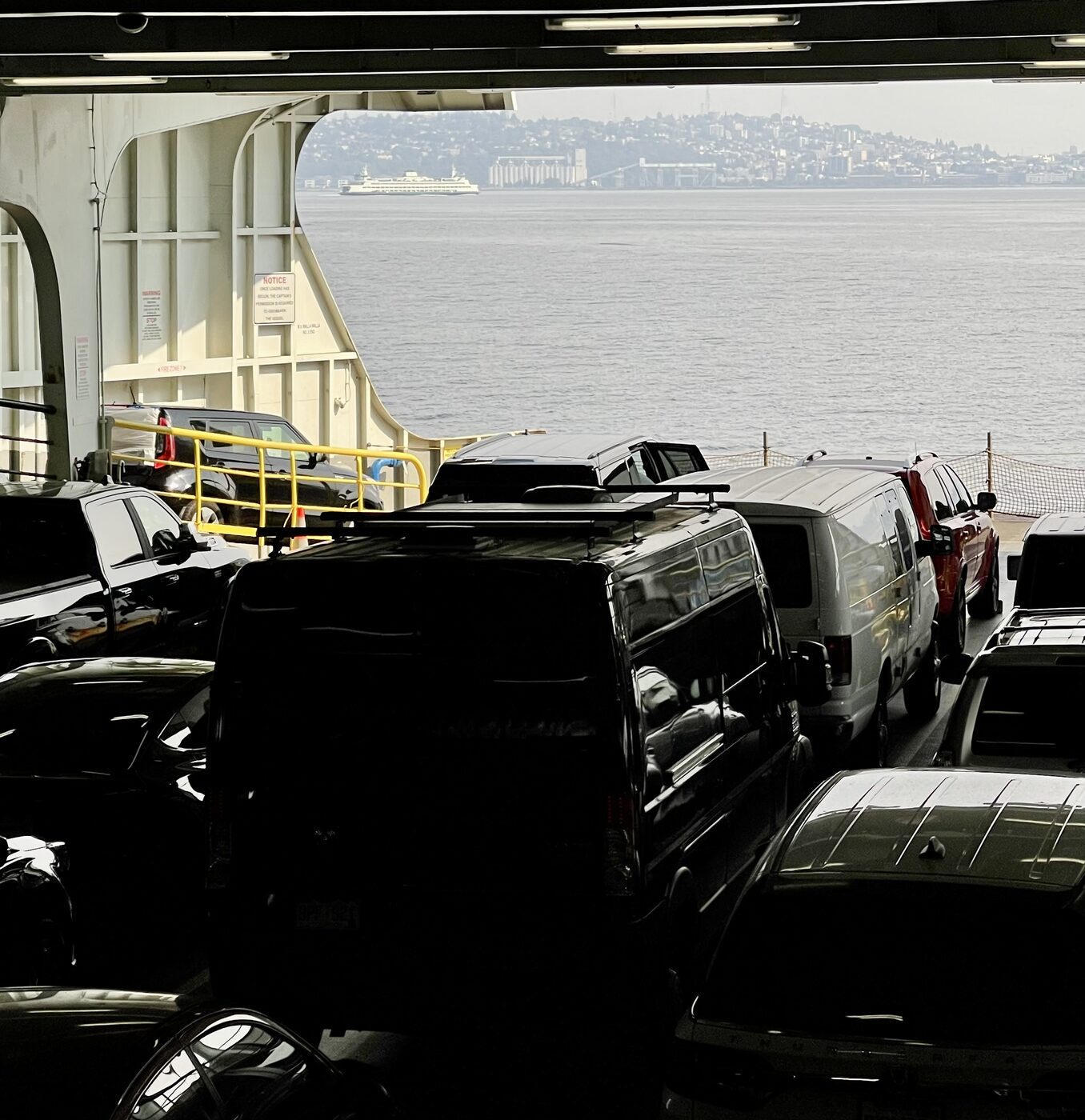 The van parked on a ferry deck, water and coastline beyond